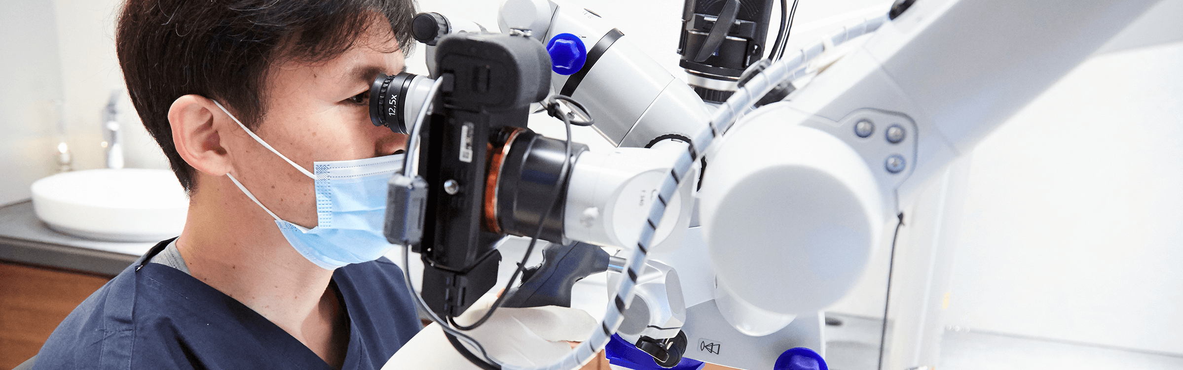 歯の内部の細菌を取り除くマイクロスコープで精緻な外科手術を実施